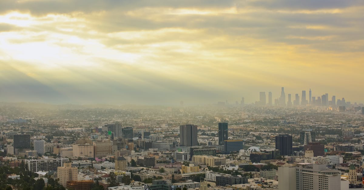 A breathtaking view of Los Angeles with sun rays piercing through clouds at dawn, capturing the city's iconic skyline.